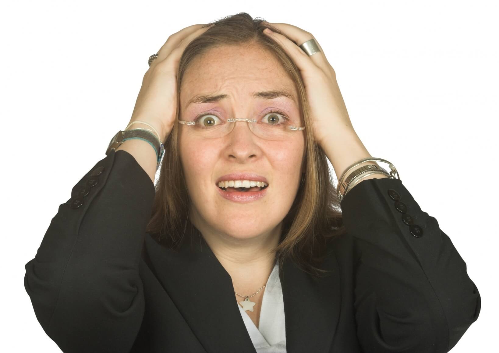 A woman in a suit holding her head with both hands.